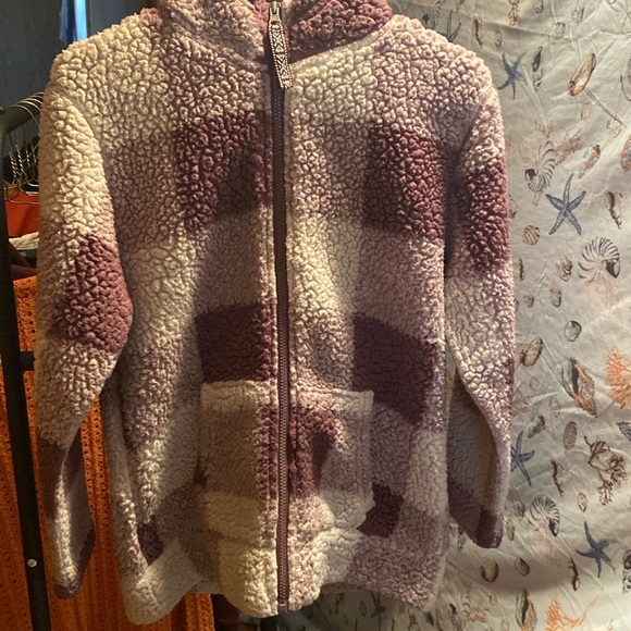 A women’s fuzzy zip up hooded sweatshirt. It’s purple and white checkered. - Picture 1 of 2